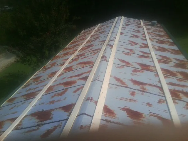 Rusted metal roof panels with new wood purlins before replacement — Storm Damage Roof Repair in Kasson by Roofing Brothers