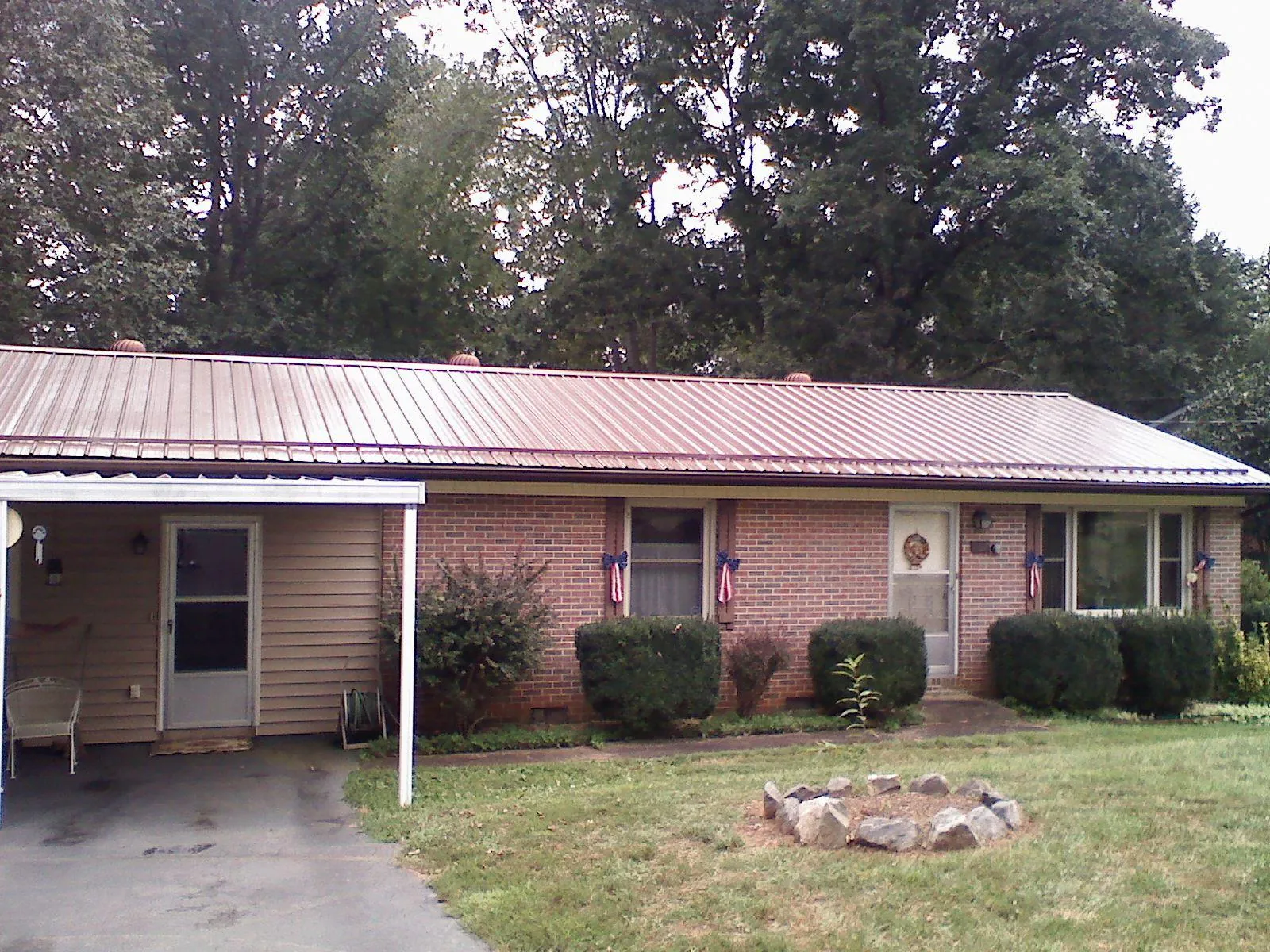 Bronze metal roof and carport on a brick ranch home — Roof Repair work by our crew in Kasson