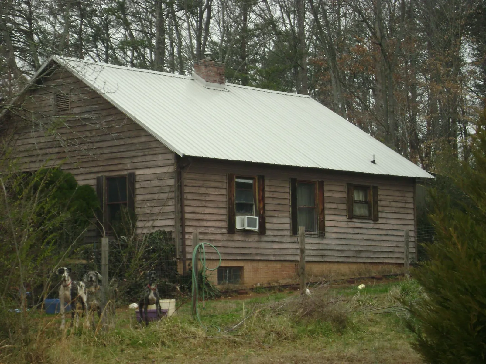 White metal roof on an old wood sided farmhouse, from a Metal Roof Installation job in Kasson